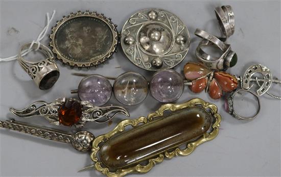 Eight assorted brooches and four rings including silver.